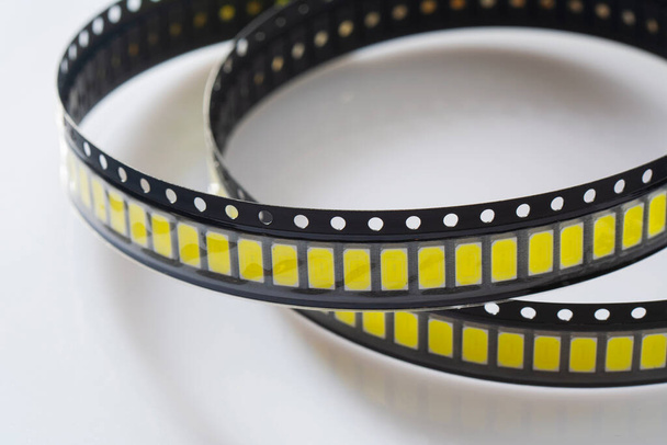 Yellow Led strip coil packaging closeup isolated on white background. Spare part for repair lamp or latern. Diode tape in the package - Photo, Image
