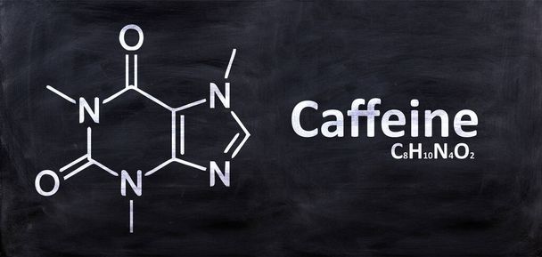 Koffein szerkezeti kémiai képlet, kréta fekete táblára rajzolva, iskolai kémia óra. Stimuláns anyag a kávéban és a teában - Fotó, kép