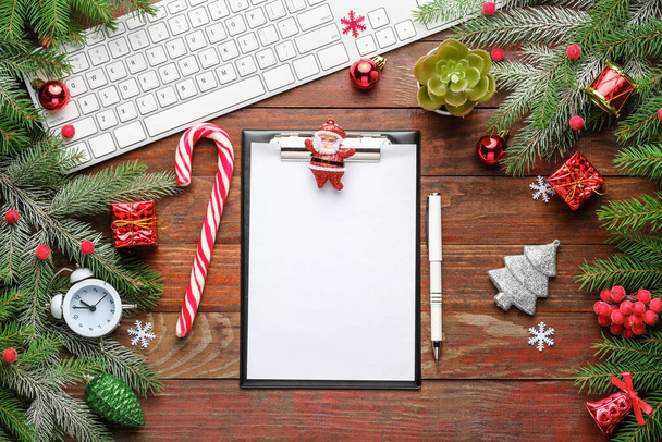 Christmas background with fir branches, keyboard, clipboard on old wooden board  - Photo, Image