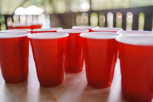 Sörpong. Piros műanyag poharak az asztalon - Fotó, kép