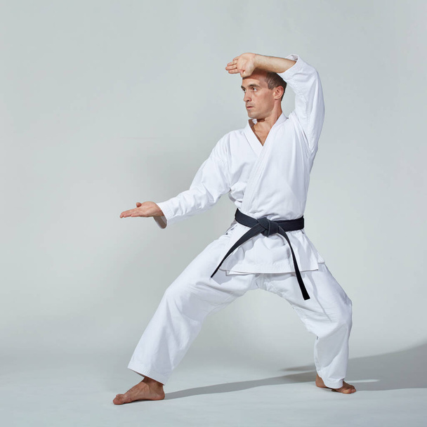 Formalne ćwiczenia karate wykonywane przez dorosłego sportowca z czarnym pasem - Zdjęcie, obraz