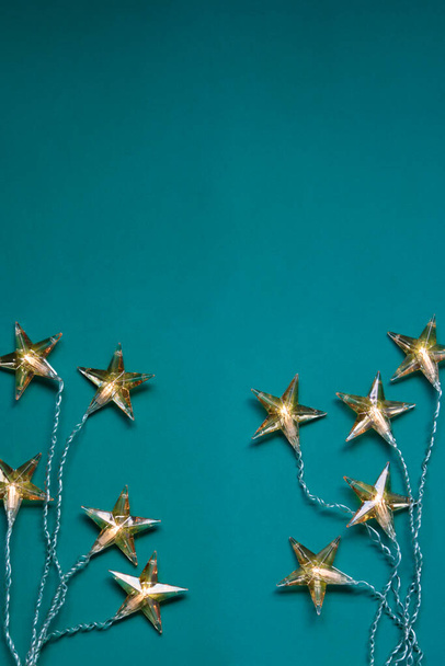 Vue du dessus des lumières de Noël en forme d'étoile sur fond vert avec espace de copie - Photo, image