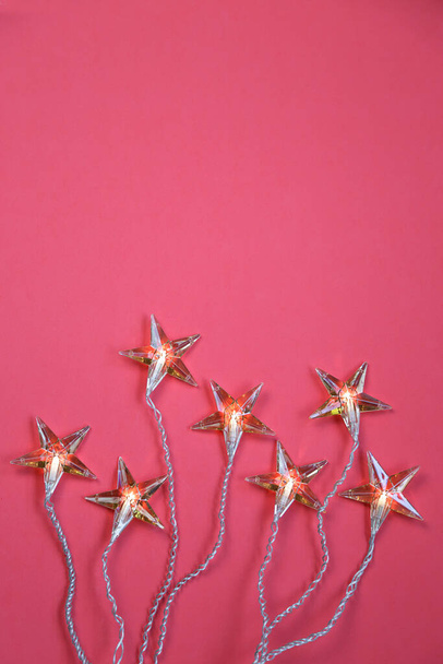 Horní pohled na hvězdy ve tvaru vánoční světla proti korálové barvy pozadí s kopírovacím prostorem - Fotografie, Obrázek