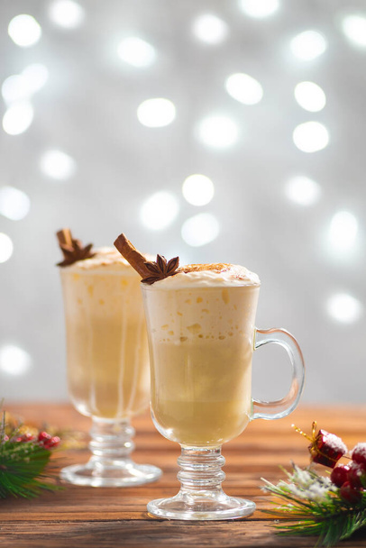 Vertical image of festive cinnamon eggnog for the Christmas holidays. Winter celebration table and drinks.Home decoration - Fotó, kép