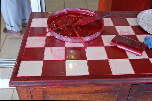 Rode kleurstof op rood geruite tafel in de Hindoe Tempel van Ganga Talao in Mauritius - Foto, afbeelding