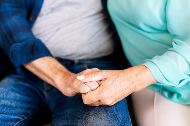 Senior couple holding hands sitting at home - Foto, Bild
