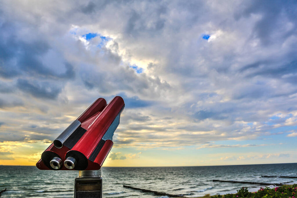 Κυάλια που λειτουργούν με κέρμα για να παρακολουθήσουν ένα δραματικό ουρανό πάνω από τη Βαλτική Θάλασσα - Φωτογραφία, εικόνα