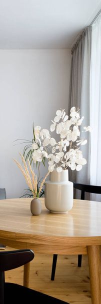 Vertical panorama of two stylish vases and decorative plants on wooden dining table - Foto, immagini