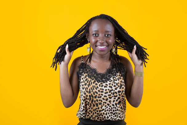 beautiful young african female on yellow background - Zdjęcie, obraz