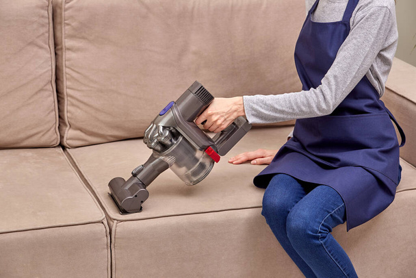 Womens hands removing dust from the sofa Home routine. - Foto, Imagem