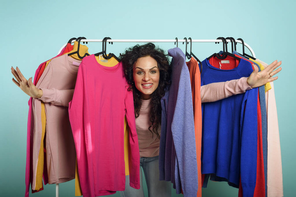 Женщина выбирает одежду для покупки в магазине. Концепция покупок и шопоголика. - Фото, изображение