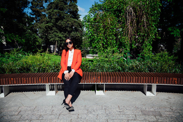 Schöne Mode-Geschäft brünette Frau sitzt auf einer Bank auf der Straße ausruhen - Foto, Bild