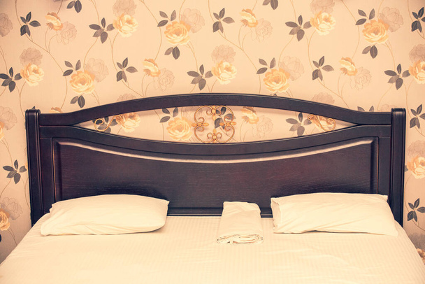 Двуспальная кровать в номере отеля. Кровать в номере отеля. Кровать и подушки. - Фото, изображение