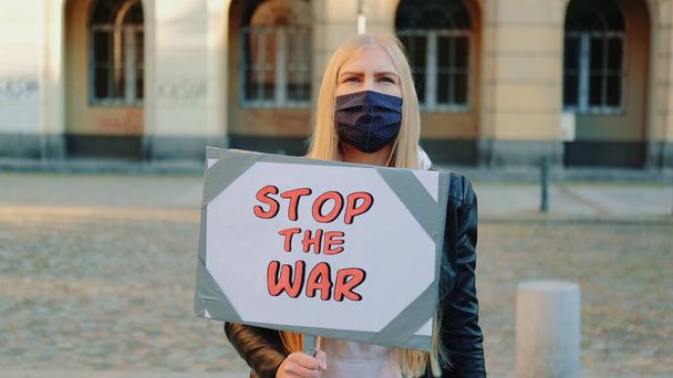 Junge Frau ruft dazu auf, den Krieg zu beenden, indem sie Dampfer hält - Foto, Bild