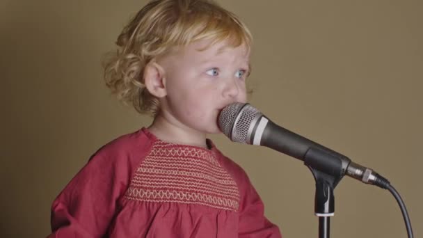 Cute little girl sing song into microphone, funny toddler enjoing broadcasting - Footage, Video