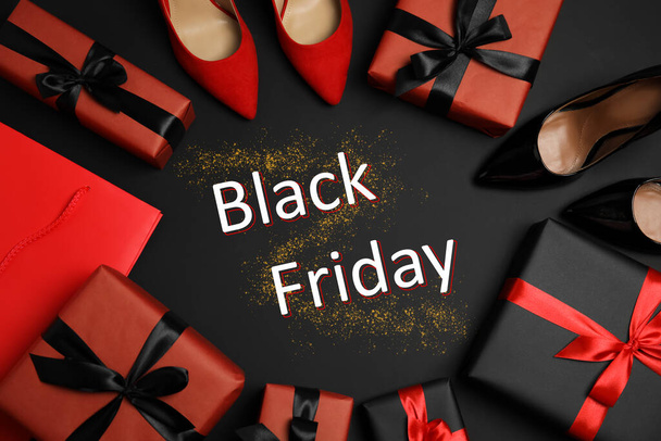 Flat lay composition with stylish women's shoes, gift boxes and phrase Black Friday on dark background - Zdjęcie, obraz