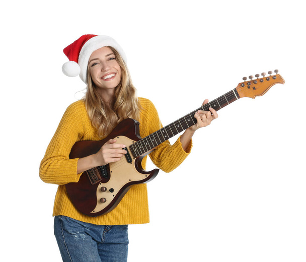 Young woman in Santa hat playing electric guitar on white background. Christmas music - Zdjęcie, obraz