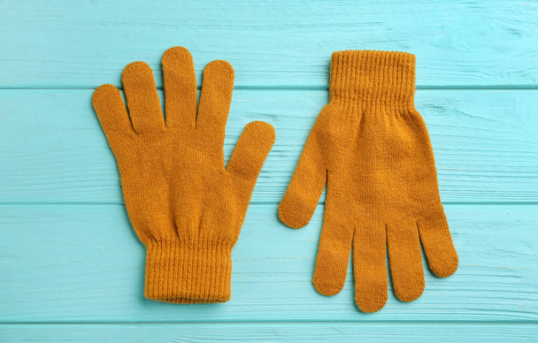 Stylish gloves on turquoise wooden background, flat lay - Фото, изображение
