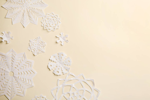 Many paper snowflakes on light background, flat lay. Space for text - Foto, afbeelding