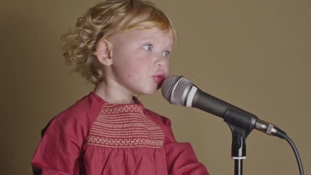 Χαριτωμένο κοριτσάκι τραγουδούν το τραγούδι στο μικρόφωνο, αστείο μικρό παιδί απολαμβάνοντας τη μετάδοση - Πλάνα, βίντεο