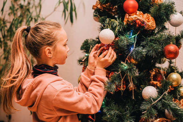 child little girl near christmas tree at home. Christmas teenager girl christmas tree. - Fotografie, Obrázek