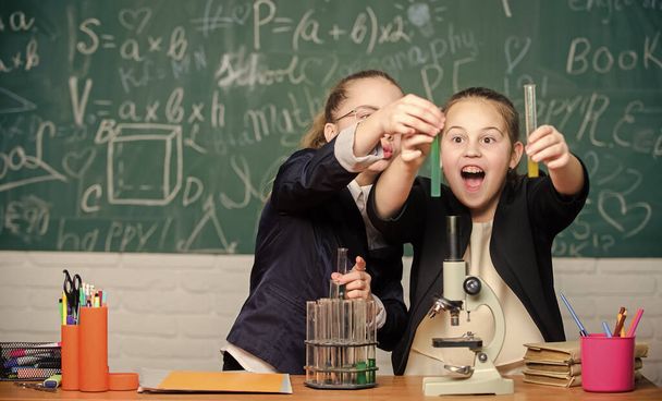 Kislányok az iskolai laborban. Kémia oktatás. A kis tudós mikroszkóppal dolgozik. Kémiai kutatás. Biológia óra. kémiai laborban végzett tudományos kísérletek. Szakmai választás - Fotó, kép