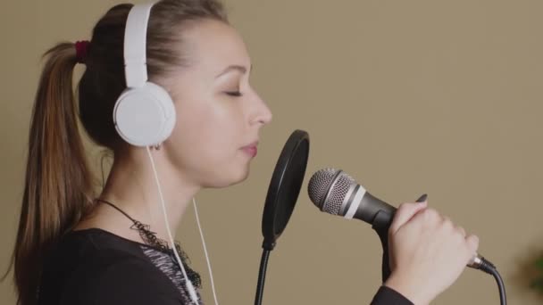 Ziemlich musizierend im Kopfhörer singt mit sinnlichen Gefühlen ein Lied ins Mikrofon - Filmmaterial, Video