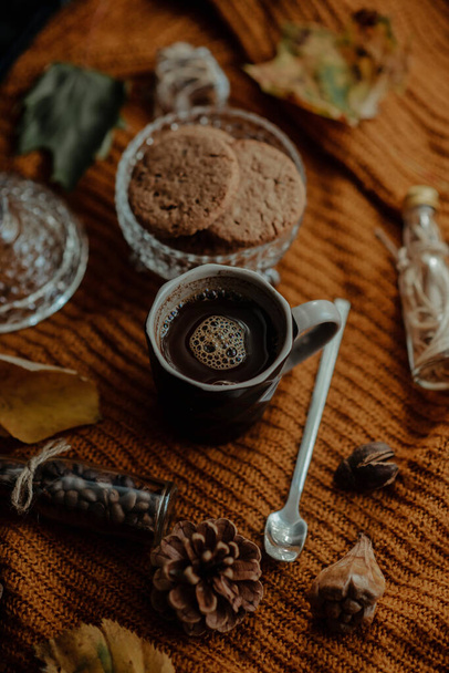 A vertical shot of tasty cookies and coffee in an autumn decoration set - Foto, Bild