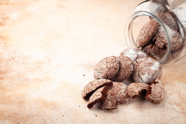 Sweet chocolate cookies scattered from transparent glass bank - Фото, зображення