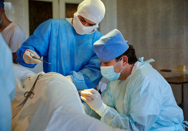 Cirugía. El cirujano, con la ayuda de su asistente, realiza la operación. - Foto, Imagen
