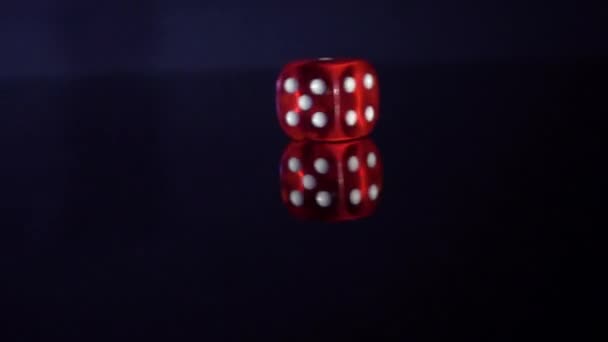 Movimento lento de rolar cubos de jogo na mesa preta.Rolamento de dados de casino vermelho - Filmagem, Vídeo