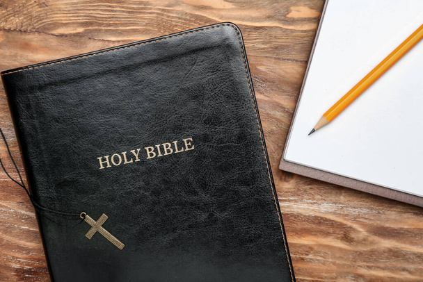 Kutsal İncil, haç ve defter tahta masanın üzerinde. - Fotoğraf, Görsel