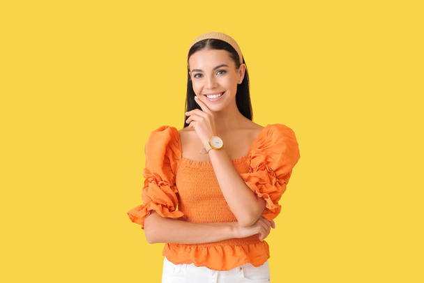 Young woman with wristwatch on color background - Photo, image