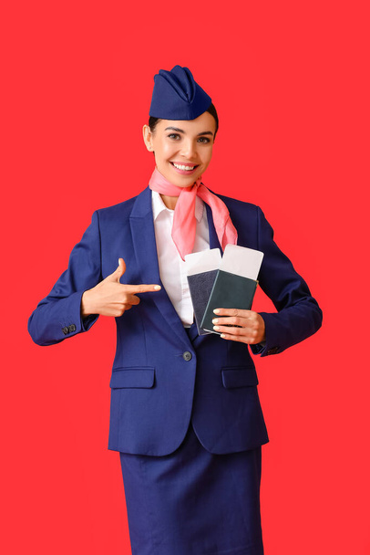 Красивая стюардесса с документами на цветном фоне - Фото, изображение