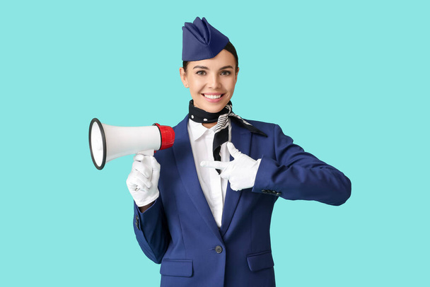 Schöne Stewardess mit Megafon auf farbigem Hintergrund - Foto, Bild