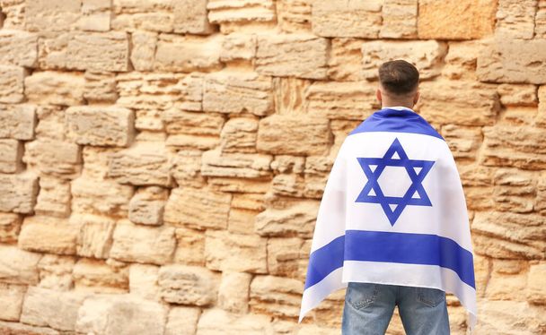 Человек с флагом Израиля возле Стены Плача - Фото, изображение