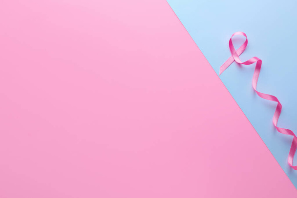 Pink ribbon on color background. Breast cancer awareness concept - Photo, Image