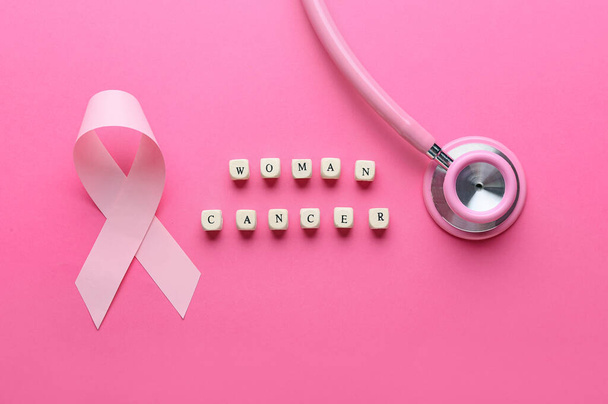 Fita rosa, estetoscópio e texto WOMAN CANCER sobre fundo de cor - Foto, Imagem