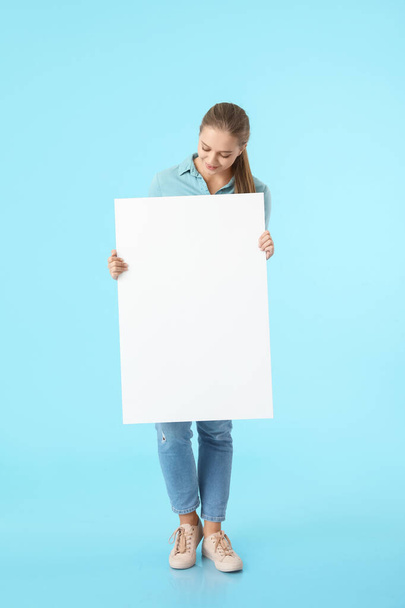Красивая девушка с чистым плакатом на цветном фоне - Фото, изображение