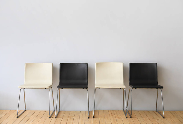 Moderne stoelen bij lichte muur - Foto, afbeelding