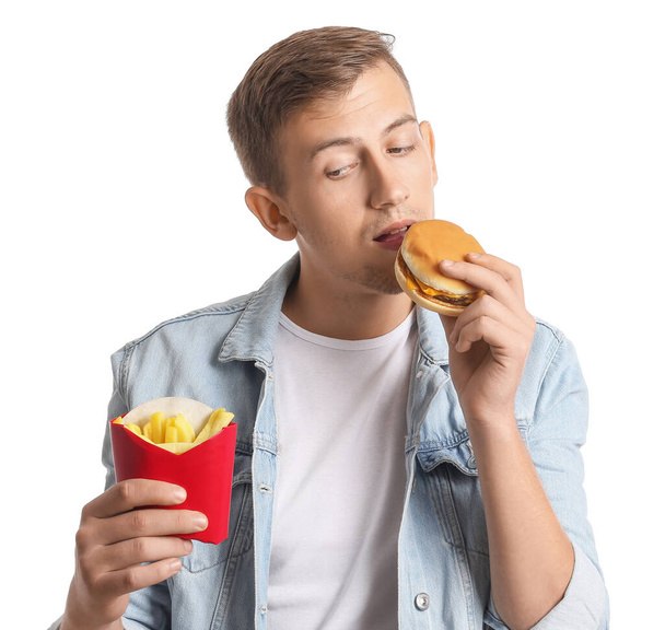 Young man with french fries and burger on white background - Fotoğraf, Görsel
