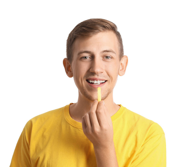 Young man with french fries on white background - Fotografie, Obrázek