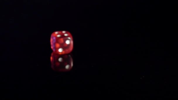 Lassú mozgása gördülő játék kockák a fekete asztalon.Rolling piros kaszinó kocka - Felvétel, videó