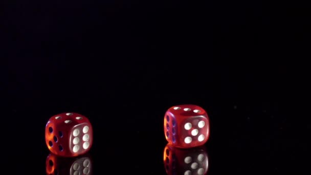 Langzame beweging van rollende spel kubussen op de zwarte tafel.Rollende rode casino dobbelstenen - Video
