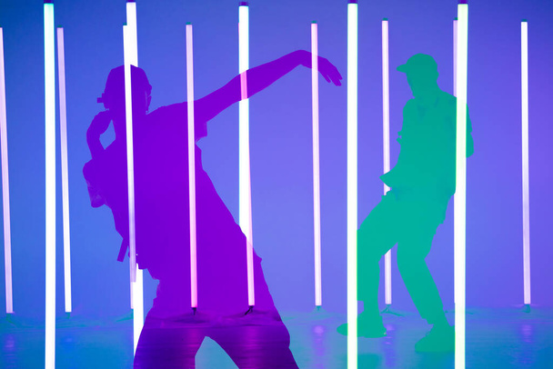 Collage of shadows handsome person doing hip hop elements on neon lamps background. Close up man dancing at party in night club. Dance school poster. - Фото, изображение