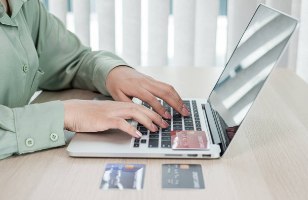Die Hand der Geschäftsfrau hält eine Kreditkarte und benutzt einen Laptop für Online-Einkäufe und Internet-Zahlungen im Büro. - Foto, Bild