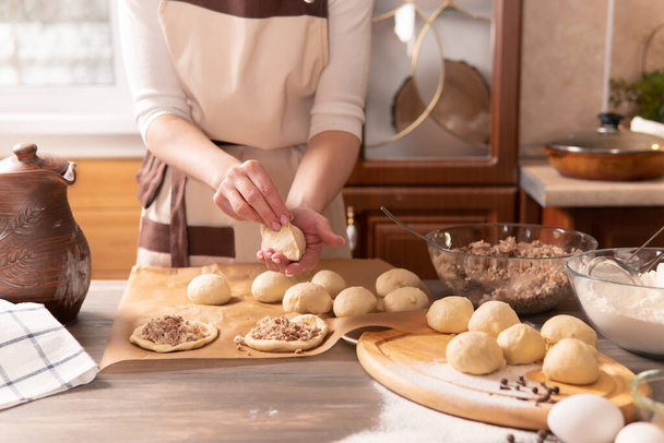 Mulher bonita prepara tortas na cozinha em casa para sua família. Ela faz pão. - Foto, Imagem