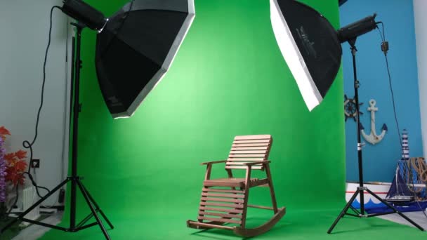 Altı köşeli stüdyo ışıkları olan fotoğraf ya da video stüdyosu. Yeşil ekran ve sallanan sandalye - Video, Çekim