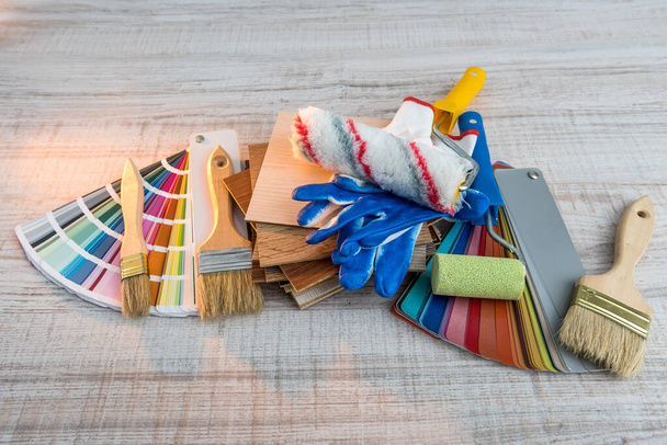 conjunto de pinceles de pintura bandeja de rodillos y paleta de papel de color sobre tabla de madera. Reparación casera  - Foto, imagen