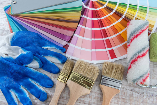 Εργαλείο παλέτα χρωμάτων και πινέλο, μπλε γάντια για την επισκευή του σπιτιού. Ιστορικό οικιακής εργασίας - Φωτογραφία, εικόνα